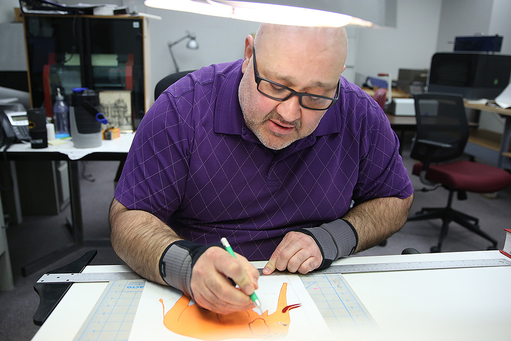 man drawing tactile graphics for Clovernook Center