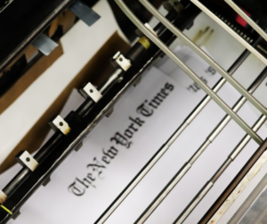 New York Times print title pages being embossed with braille on an adapted Heidelberg press.