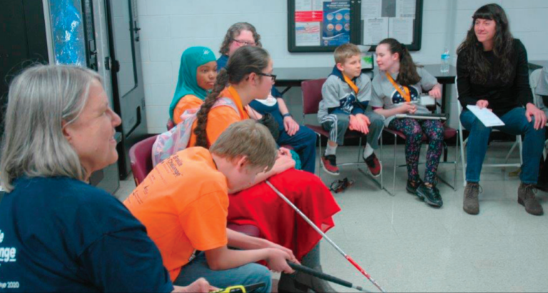 volunteers sitting with children who are blind