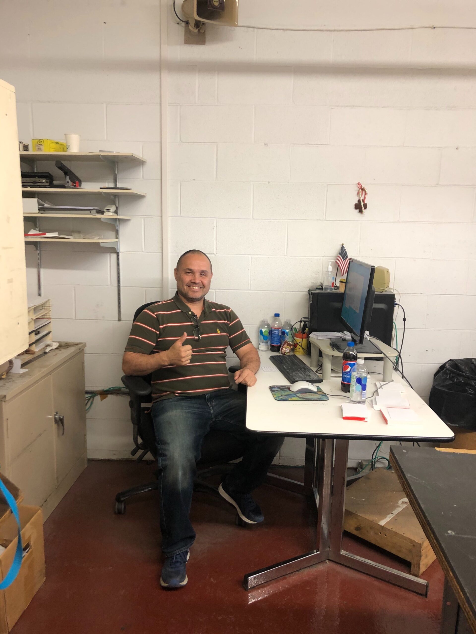 man sitting at desk giving thumbs up