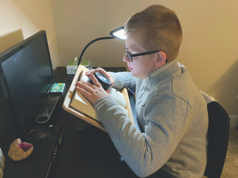 Drew uses his magnifying dome for reading and homework.