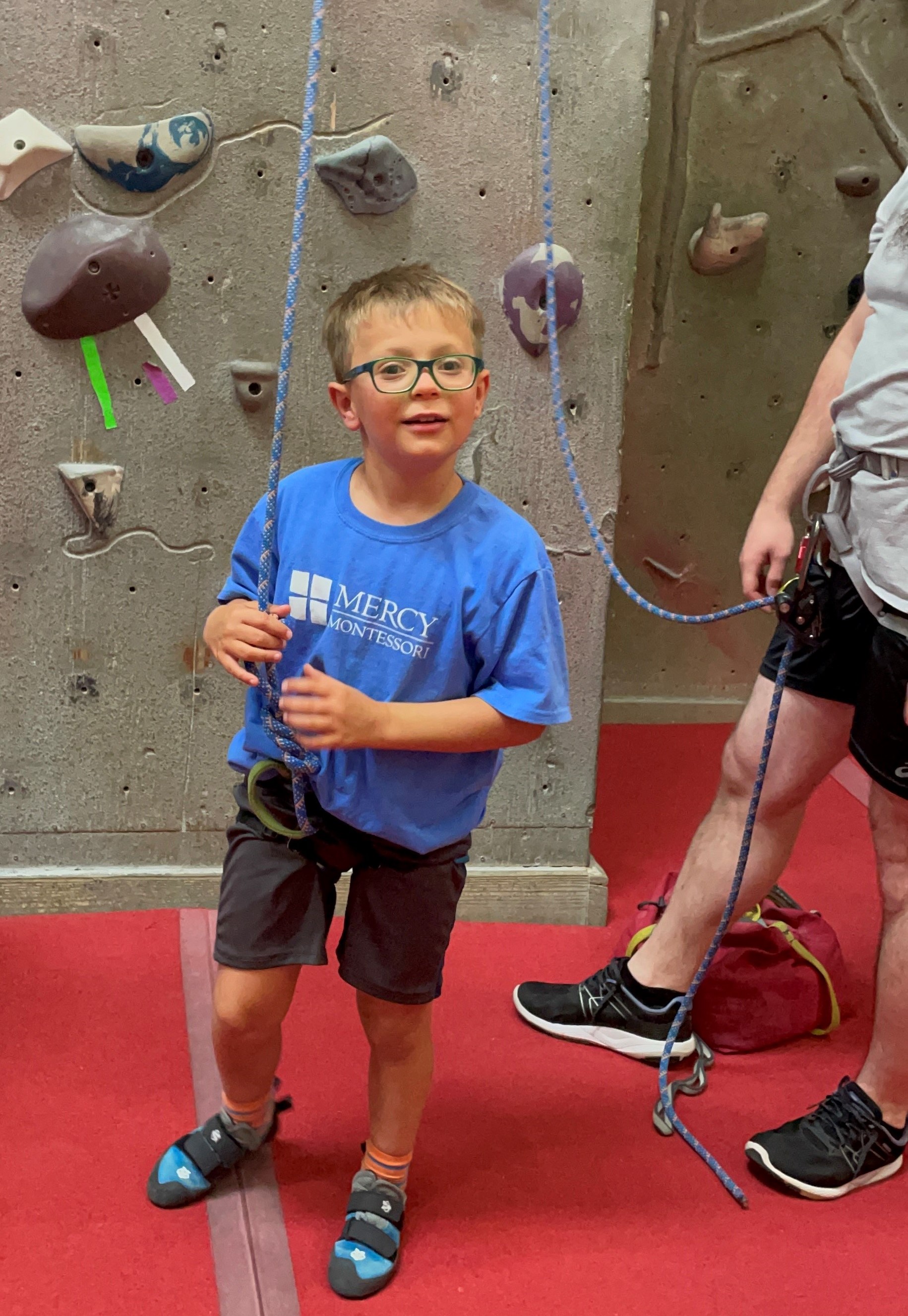 Photo of Dawson (a Clovernook client) partake in rock climbing through the Adaptive Sports program