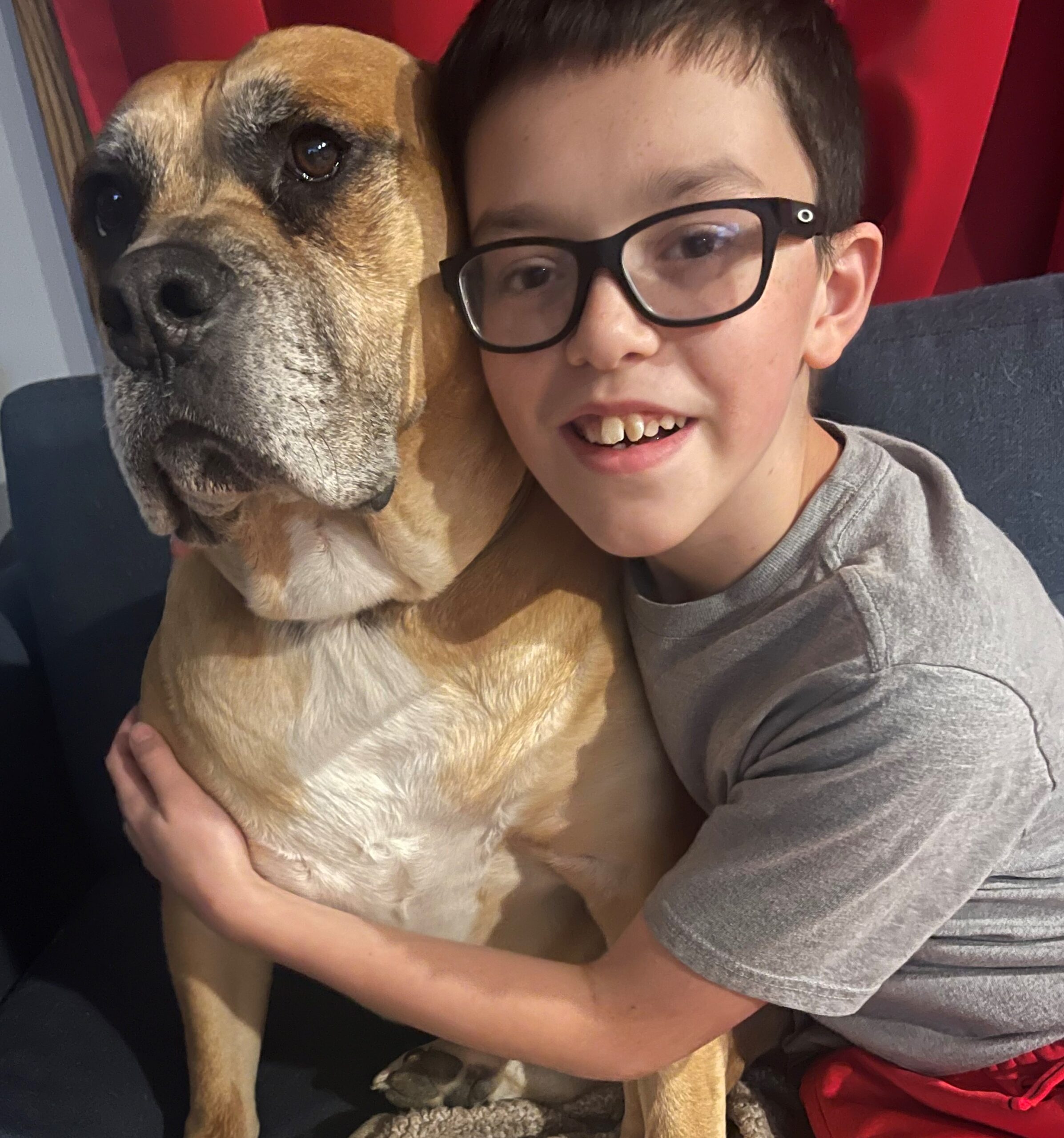 Jesse smiling and hugging his dog