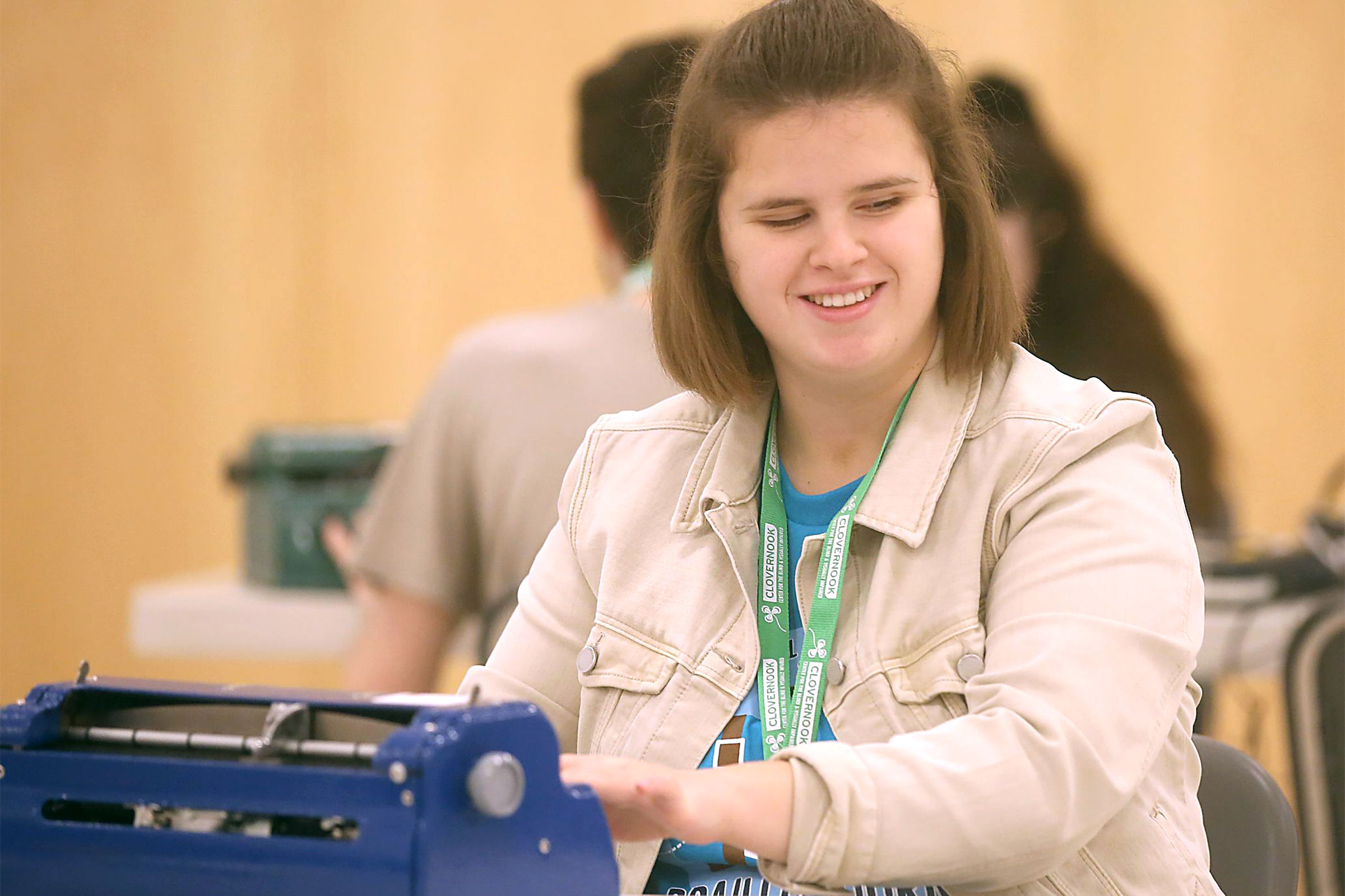 A teen using a braille typewriter.