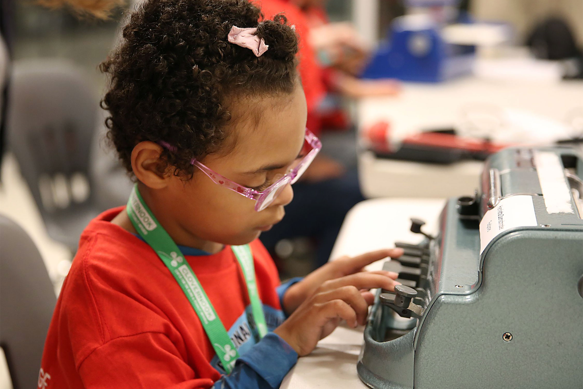 A young girl using a braille typewriter.