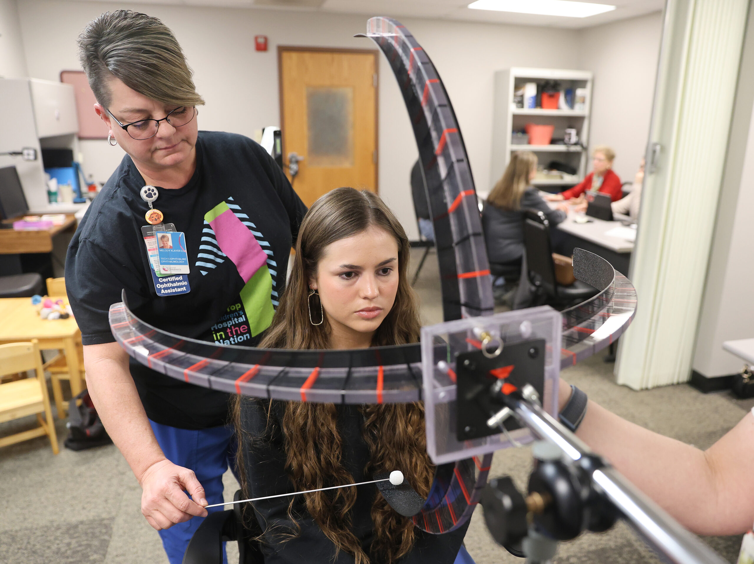 Low Vision Clinic employee conducts vision exam on girl.