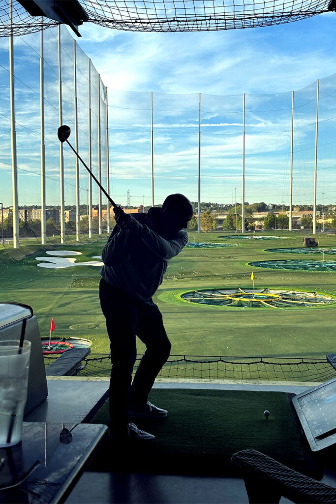 A golfer swings his club as he participates in the Golf Extravaganza.