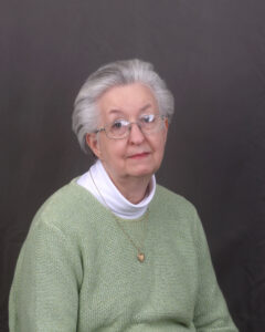 Charlotte Begley smiles softly at the camera in a portrait photo