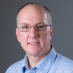 Dennis Hahn smiles in a portrait photo.